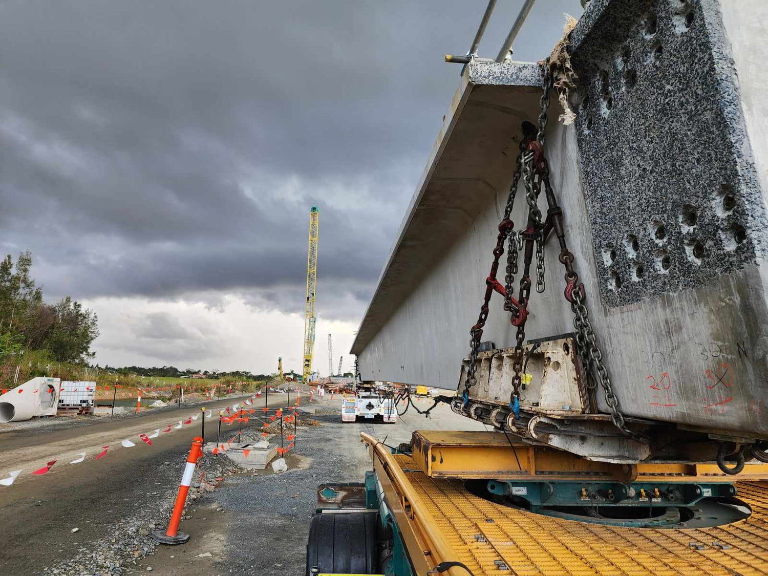 Construction site with large concrete bridge segment and crane