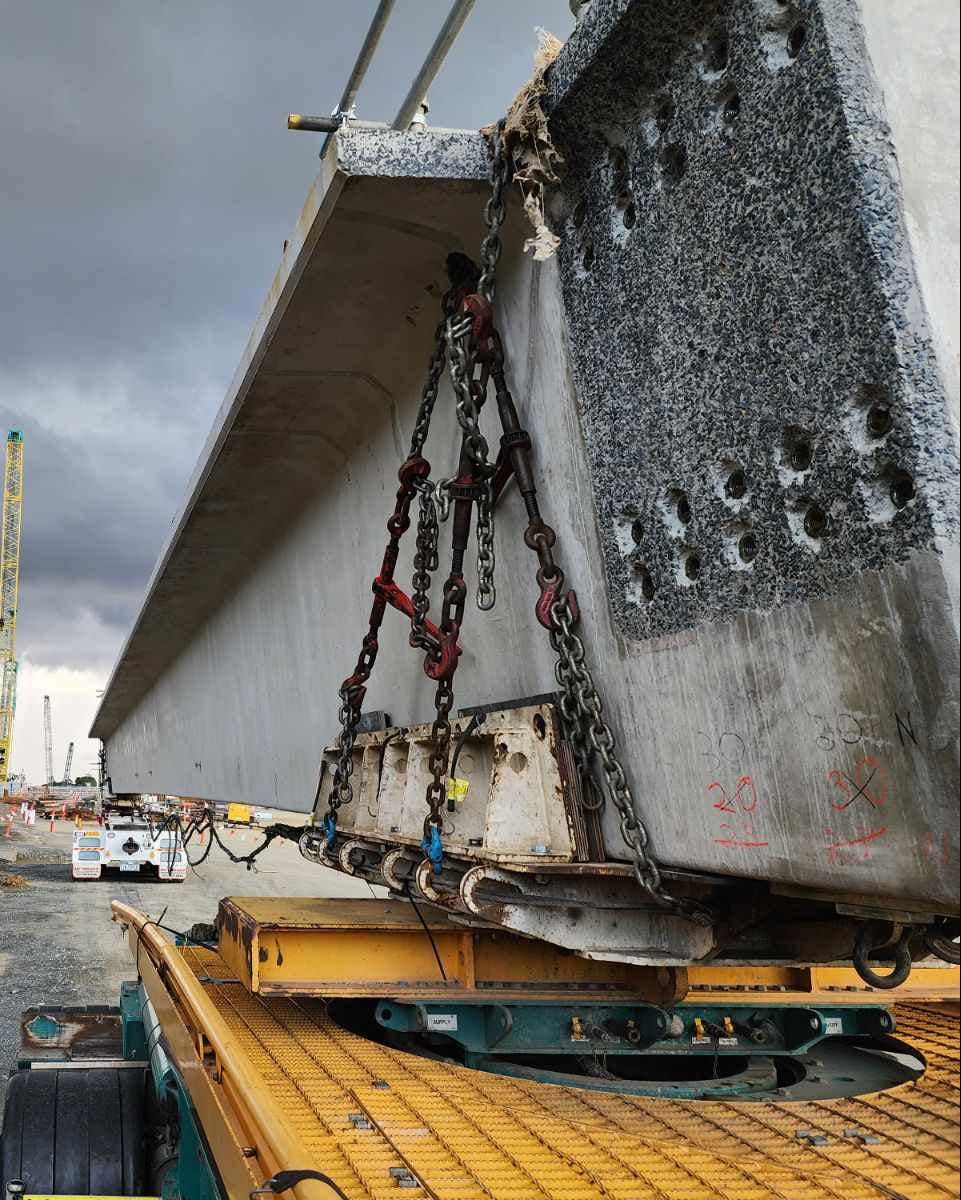 Construction site with large concrete bridge segment and crane
