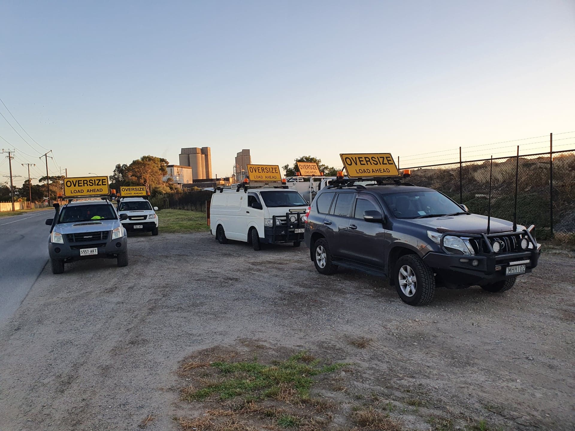 Vehicles with oversize load signs on a road 